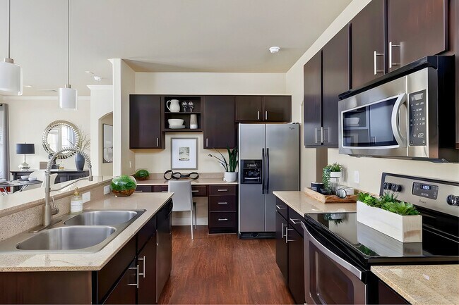 Cocina modelo con electrodomésticos de acero inoxidable - Ladera Apartment Homes