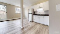 Located at 800 Exmouth St in Sarnia, Ontario, this 2-bedroom unit offers a practical and well-appointed layout across a single floor. Throughout the space, light-toned hardwood-style flooring creates a clean, cohesive aesthetic that ties each room together seamlessly.

The open living room is a highlight of the unit, featuring large sliding glass doors that flood the space with natural light and provide views of the surrounding neighbourhood. A second window further enhances the bright, airy atmosphere. Baseboard heating runs along the walls, ensuring comfortable warmth throughout the seasons.

Adjacent to the living room, the kitchen is outfitted with crisp white cabinetry, dark countertops with a subway tile backsplash, a stainless steel refrigerator, and a built-in sink — offering both style and functionality in a compact, efficient layout.

The primary bedroom is a well-sized, quiet retreat featuring a large window with natural views and a full-height sliding closet with clean white panel doors, providing ample storage. The second bedroom mirrors the unit's consistent style with its own window and baseboard heating.

Neutral warm-beige walls throughout the unit complement the flooring and contribute to a calm, welcoming ambiance. The overall design is clean, modern, and move-in ready, making this an ideal space for those seeking comfortable urban living in Sarnia.