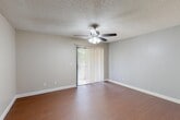 Located at 3555 W Bullard Ave in Fresno, CA, this well-organized one-bedroom, one-bathroom unit is thoughtfully laid out across a single floor. The living room is a bright, open space featuring warm wood-look flooring, a ceiling fan with light fixture, and a sliding glass door fitted with vertical blinds that invite natural light and provide outdoor access. Adjacent to the living area, a defined dining space flows naturally into the galley-style kitchen, which is equipped with rich dark wood cabinetry, white countertops, a double sink, and a full suite of white appliances including a refrigerator, electric range, microwave, and dishwasher. A window above the kitchen sink adds additional natural light. The bedroom is a comfortable, carpeted retreat featuring a sliding double-door closet, a window with outdoor views, and a textured ceiling. The bathroom is clean and functional, offering a vanity with a large mirror, light countertop, and wood cabinetry. A hallway connects the main living areas to the bedroom and bathroom, with three closets throughout the unit providing generous storage. Textured ceilings and neutral wall tones are consistent throughout, creating a cohesive and practical living environment.