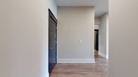 This well-designed apartment offers 1290 square feet of living space spread across a single floor. The layout includes two bedrooms, two bathrooms, a combined kitchen and living room area, and three closets for ample storage. The primary bedroom is generously sized at 170 square feet, providing a comfortable retreat.

The living areas are characterized by their openness and abundance of natural light. As seen in the image, large windows with white blinds dominate one wall, offering expansive views and flooding the space with daylight. The room features neutral-toned walls and gleaming hardwood floors, creating a bright and inviting atmosphere.

The apartment's open floor plan seamlessly integrates the kitchen and living room, ideal for modern living and entertaining. Two hallways provide easy access to all areas of the home. While specific details about the bathrooms and kitchen are not provided, the overall square footage suggests well-proportioned spaces throughout.

This apartment combines functionality with aesthetic appeal, making it suitable for various lifestyles. Its neutral palette and contemporary finishes provide a blank canvas for personalization, while the abundance of natural light and open spaces create a welcoming and airy environment.