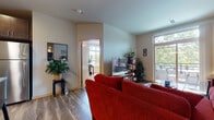 Located at 722 Bruce Ct in Madison, WI, this single-floor unit offers a thoughtfully designed layout across several distinct living spaces. The living room serves as the heart of the home, featuring wood-style flooring, vaulted ceilings, and large windows that frame outdoor greenery. Floating shelves and wall art add character, while access to an outdoor balcony enhances the connection to the surrounding landscape.

The kitchen is well-appointed with dark espresso cabinetry, granite countertops, stainless steel appliances including a refrigerator, microwave, and range, and light wood-style flooring that ties the space together cohesively. An adjacent dining area accommodates a full dining table set and offers convenient closet storage nearby.

The primary bedroom is a standout, featuring wrap-around windows that flood the carpeted space with natural light and treetop views. A ceiling fan adds comfort, and the room offers generous space for a workspace or seating area. The second bedroom is cozily appointed with carpeting and a window. Both bathrooms feature dark cabinetry, granite countertops, and tile flooring, providing a consistent, polished finish throughout.