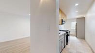 This 2-bedroom, 1-bathroom single-floor unit offers a clean, functional layout with a bright, neutral aesthetic throughout. Light hardwood flooring spans the main living areas and bedrooms, creating a cohesive and airy feel across the entire space.

The living room is generously sized, featuring recessed lighting and large windows fitted with horizontal blinds that welcome an abundance of natural light. The kitchen is positioned adjacent to the living area and includes warm-toned wood upper cabinetry, gray lower cabinets, a gas range with over-the-range microwave, and tile flooring, offering a practical and well-equipped cooking space.

Both bedrooms are bright and comfortable, each with large windows that frame views of lush greenery outside. The primary bedroom includes a closet and ample wall space, while the second bedroom also benefits from recessed lighting and direct hallway access. Two closets provide additional storage throughout the unit.

The bathroom is neatly finished with a full soaking tub and shower combo, a window for natural ventilation, tile flooring, and a wood-toned vanity. A wall-mounted HVAC unit in the bedroom area ensures climate control year-round.

Overall, this unit presents a clean, move-in-ready environment with consistent finishes, plentiful natural light, and a straightforward, efficient floor plan.