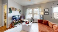 Located at 1017 London Rd in Duluth, Minnesota, this efficient single-floor studio offers a thoughtfully organized layout that maximizes every square foot. The open-plan kitchen and living area forms the heart of the unit, where warm honey-toned hardwood flooring flows throughout and a textured ceiling adds character overhead. The kitchen is outfitted with rich wood cabinetry extending to the ceiling for generous storage, granite-style countertops, a double sink, and black appliances including a gas range and full-size refrigerator. The living area transitions seamlessly from the kitchen, providing comfortable space for lounging and entertaining. A ceiling fan with light fixture keeps the room well-ventilated, while large windows along one wall invite abundant natural light and offer views of the surrounding tree-lined exterior. A baseboard heating unit ensures warmth during Duluth's cold seasons. The unit also includes a dedicated closet for storage needs. The bathroom features a full tub and shower combination with clean white surroundings and a decorative curtain. Neutral gray walls throughout the unit create a versatile backdrop, making this a practical and functional space in a convenient Duluth location.