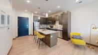 Located at 222 N 22nd St in Lincoln, Nebraska, this well-appointed one-bedroom, one-bathroom unit offers a thoughtfully designed open-concept floor plan. Light wood-tone flooring flows throughout the main living area, creating a cohesive and contemporary aesthetic. The kitchen is a standout feature, showcasing dark shaker-style cabinetry, a classic white subway tile backsplash, granite countertops, and a full suite of stainless steel appliances including a refrigerator, range, microwave, and dishwasher. A center island with granite top and bar seating provides additional prep space and casual dining options, illuminated by pendant lighting overhead. The kitchen opens seamlessly into the dining and living areas, where recessed lighting and a large sliding glass door flood the space with natural light and provide direct outdoor access. The bedroom is a comfortable retreat featuring plush carpeting, a ceiling fan, a generous window with outdoor views, and two closets offering ample storage, including a walk-in closet with wire shelving. The bathroom mirrors the refined finishes found throughout, with granite countertops, dark cabinetry, and wood-look flooring. This unit combines modern design with practical functionality in a well-organized, efficiently utilized layout.