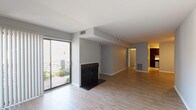 Located in the Saddlebrook neighborhood of Lexington, Kentucky, this single-floor residence offers a thoughtfully arranged layout visible across its interconnected living spaces. The main living area makes a strong impression with light hardwood-style flooring, neutral gray walls, and a classic fireplace with a dark surround serving as a natural focal point. A large sliding glass door floods the space with natural light and provides direct access to an outdoor patio area, where greenery is visible beyond. Vertical blinds frame the door, offering adjustable privacy and light control.

The open layout connects seamlessly to additional living or dining space, maintaining the same clean hardwood flooring and a simple, modern aesthetic throughout. The kitchen is well-appointed, featuring dark espresso cabinetry that contrasts sharply with light speckled countertops, a stainless steel double-basin sink, a stainless dishwasher, and a black electric range. Ample upper and lower cabinet storage provides functional utility.

The bedroom is generously proportioned, finished with plush carpet and a sliding glass door with vertical blinds that introduce additional natural light. The bathroom presents a straightforward, clean design with a vanity featuring dark cabinetry, a wide mirror with built-in shelving, and a separate toilet compartment. Throughout the space, the consistent neutral color palette and practical finishes create a cohesive, move-in-ready environment.