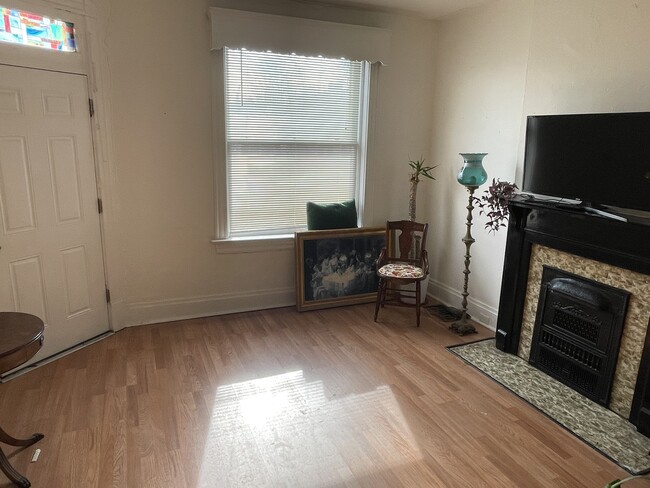 Front, south facing room. Featuring a decorative fireplace and pocket door. - 5313 Magnolia Ave