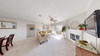 Located at 7401 W Washington Ave in Las Vegas, NV, this well-appointed 3-bedroom, 2-bathroom single-floor residence offers a thoughtfully designed layout across a comfortable footprint. The bright and airy living room serves as the heart of the home, featuring plush carpet, a ceiling fan, crown molding, and a fireplace framed by a clean white surround. Sliding glass doors open to a private balcony, filling the space with natural light and providing outdoor access. Adjacent to the living area, the dining room features crown molding and neutral tones, creating an inviting setting for meals and gatherings. The kitchen is outfitted with white shaker cabinets, light countertops, a subway tile backsplash, stainless steel appliances, and wood-look flooring — a clean, modern space designed for functionality. The primary bedroom is generously sized, complete with a ceiling fan, carpeted flooring, and a dedicated bathroom. Additional bedrooms also feature ceiling fans and ample natural light. Both bathrooms are finished with white countertops and bright vanity lighting. The residence also includes two closets, one of which is a walk-in with wire shelving, and a hallway connecting the main living spaces seamlessly.