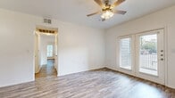 Located at 711 River Rd in Boerne, TX, this single-story, 3-bedroom, 2-bathroom home offers a practical and cohesive layout designed for comfortable everyday living. Wood-look plank flooring runs throughout the entire home, lending a clean, unified aesthetic to every room.

The combined kitchen and living area serves as the heart of the home. The galley-style kitchen is well-equipped with rich, warm-toned cabinetry, a double-basin sink with light countertops, and black and stainless steel appliances including a refrigerator, range, and microwave. Pendant and flush-mount lighting illuminate the space efficiently.

The living area connects seamlessly to the kitchen and features a ceiling fan and French doors that open to the exterior, allowing natural light to flow in. Each of the three bedrooms is a well-sized, comfortable space featuring ceiling fans and windows with blinds that provide natural light while maintaining privacy. The generously sized primary bedroom offers ample room for furnishings.

Both bathrooms maintain a consistent design language, featuring rich wood-toned cabinetry, light countertops, tub-shower combinations with handheld fixtures, and the same wood-look flooring carried throughout the home. A hallway connects the bedrooms and bathrooms, providing a logical and efficient flow across the single floor.
