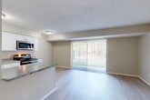 Located at 5955 Edinburgh St in Canton, MI, this single-floor, 2-bedroom, 1-bathroom residence offers a thoughtfully designed layout that maximizes comfort and functionality. The open-concept living and dining area is bathed in natural light, courtesy of a large sliding glass door with vertical blinds that opens to an outdoor view, creating a bright and airy atmosphere. Light-toned luxury vinyl plank flooring runs throughout the main living spaces, lending a clean, contemporary feel.

The galley-style kitchen is well-equipped with crisp white shaker cabinetry, marble-look countertops, and a full suite of stainless steel appliances including a refrigerator, range, microwave, and dishwasher. A peninsula counter connects the kitchen to the living and dining area, enhancing the open flow of the space.

Both bedrooms offer comfortable proportions — the primary bedroom features plush carpeting and a double-door closet, while the second bedroom includes light hardwood-style flooring and its own closet. Three closets throughout the unit provide ample storage. The bathroom is clean and functional, featuring a full soaking tub and shower combination. A textured ceiling finish is consistent throughout the home, adding subtle character to the overall design.