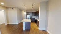 Located on Outlet Blvd in Fort Worth, Texas, this thoughtfully designed single-floor residence blends contemporary style with functional living. The open-concept layout centers around a striking kitchen, where rich dark-wood cabinetry, light granite countertops, and a classic subway tile backsplash create a polished aesthetic. A large central island with an undermount sink and elegant pendant lighting serves as both a prep space and a gathering point, while stainless steel appliances and track lighting complete the modern look. Warm hardwood flooring flows throughout the main living and kitchen areas, adding depth and continuity to the space. The bedrooms offer a comfortable retreat, each featuring plush carpeting, ceiling fans, and windows with blinds that invite natural light while maintaining privacy. One bedroom is finished with hardwood flooring, providing a versatile flex space. Both bathrooms are well-appointed with dark wood vanities, granite countertops, expansive mirrors, and clean white subway tile surrounding the tub-shower combinations. Large-format tile flooring in the bathrooms adds a refined, spa-like quality. Overall, the residence presents a cohesive, modern design with quality finishes throughout.