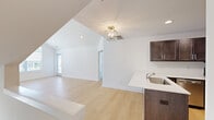 Located at 32980 Redstone Drive in New Baltimore, Michigan, this 2-bedroom, 2-bathroom home offers a thoughtfully designed single-floor layout with modern finishes throughout. The open-concept kitchen and living area is a central highlight, featuring soaring vaulted ceilings that create an airy, expansive feel. Light hardwood flooring flows throughout the main living spaces, complemented by crisp white walls and recessed lighting. A stylish lantern-style pendant fixture adds a refined touch to the living area, which receives natural light through a large window with outdoor views of the neighborhood.

The kitchen is well-appointed with dark espresso cabinetry, stainless steel appliances including a range, microwave, and refrigerator, and a sleek white quartz peninsula with an undermount sink — ideal for both cooking and casual dining.

The primary bedroom benefits from vaulted ceilings and a large window, while the second bedroom features plush carpeting, a ceiling fan, and a built-in double closet. Both bathrooms are finished with large-format tile and sliding glass-enclosed tub/shower combinations, dark cabinetry vanities, and white quartz countertops. A hallway and closet complete the functional layout of this clean, move-in-ready home.
