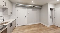 Located at 918 N Broad St in Philadelphia's vibrant Francisville neighborhood, this efficiently designed one-bedroom, one-bathroom unit offers a thoughtfully laid-out single-floor plan. Light-toned hardwood flooring runs throughout, complementing the soft gray walls and crisp white trim that give the space a clean, contemporary feel. Recessed lighting and exposed metallic ductwork add an industrial edge to the otherwise minimalist aesthetic.

The kitchen is a standout feature, equipped with a full suite of stainless steel appliances — including a refrigerator, range, microwave, and dishwasher — set against two-tone cabinetry in white and warm gray. White quartz countertops and a large window bring brightness and functionality to the cooking area.

The bedroom offers a cozy, well-proportioned retreat with access to a dedicated closet, providing practical storage. The bathroom is finished with neutral tile flooring and full tub surround, accented by matte black fixtures, a curved shower rod, and a modern vanity with sleek hardware.

A full-panel entry door with a smart lock system adds a layer of security and modern convenience. This unit's efficient use of space and contemporary finishes make it a well-appointed home in a sought-after Philadelphia location.