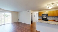 Located at 1970 River Road in Saint Clair, Michigan, this two-bedroom, two-bathroom residence offers a well-designed single-floor layout that maximizes comfort and functionality. The open-concept living and kitchen area serves as the heart of the home, where rich hardwood-style flooring flows throughout. The kitchen is thoughtfully appointed with warm honey-toned cabinetry, granite countertops, a mosaic tile backsplash, stainless steel and black appliances, and a peninsula that provides additional prep and seating space. The living area extends to a sliding glass door with vertical blinds, allowing generous natural light and outdoor access. Both bedrooms feature plush carpeting and ample closet storage. The primary bedroom benefits from direct access to its own bathroom and includes a dedicated closet. The bathrooms are finished with granite-topped vanities, warm wood cabinetry, tile flooring, and a shower-tub combination. Two closets provide practical storage throughout the unit. The clean, neutral palette and consistent finishes lend a cohesive, move-in-ready appeal to this well-maintained Saint Clair residence.