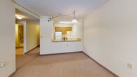 Located at 2420 Oneida St, Unit 204, in Utica, NY, this one-bedroom, one-bathroom residence offers a practical and efficient layout across a single floor. The open living area features neutral wall-to-wall carpeting and a textured ceiling, creating a clean and understated ambiance. A pass-through counter connects the living space to the kitchen, which is equipped with warm wood-toned cabinetry, a white refrigerator, a gas range, and under-cabinet lighting — all visible through the open cutout and accented by a hanging pendant light above the counter.

The bedroom is a comfortable, well-proportioned room with a window that allows natural light to filter in through horizontal blinds. A full-width sliding closet with wood-panel doors provides ample storage, and baseboard heating ensures year-round comfort. A short hallway connects the bedroom to the rest of the unit, with a flush ceiling light guiding the way.

The bathroom is bright and functional, featuring tile flooring, a white vanity with a mirror and overhead lighting, and a full tub-shower combination fitted with stainless steel accessibility grab bars — a thoughtful addition for ease of use. Overall, this unit presents a straightforward, well-maintained living space suited for comfortable everyday living.