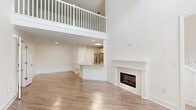 Located at 3770 George Busbee Parkway in Kennesaw, GA, this two-story residence offers a thoughtfully designed layout spread across two levels. The main floor features a dramatic living room with soaring two-story ceilings, a classic fireplace with a white-painted surround, and light wood-look flooring that flows throughout the main living areas. The open-concept kitchen and dining area is outfitted with crisp white shaker cabinetry, a full suite of stainless steel appliances, a skylight, and a peninsula with a light quartz countertop and undermount sink — ideal for both cooking and casual dining. A dedicated laundry room with a full-size washer and utility shelving adds everyday convenience on the main level. Upstairs, a white balustrade staircase leads to an open loft area with plush neutral carpeting, offering flexible space for a home office, lounge, or additional living area. The spacious primary bedroom features carpet flooring, a ceiling fan, and a window with views of surrounding greenery. The full bathroom is finished with wood-look tile flooring, a white vanity with under-cabinet storage, and clean, neutral finishes throughout. Four closets provide ample storage across the home.