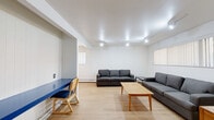 Located at 1313 S State St in Ann Arbor, Michigan, this one-bedroom, one-bathroom unit offers a well-organized single-floor layout that includes a living room, dining room, kitchen, dedicated office space, and a hallway connecting all areas. Light wood flooring runs consistently throughout, creating a cohesive and clean aesthetic.

The living room is generously proportioned, featuring recessed track lighting and a horizontal window fitted with vertical blinds that allow for natural light. The dining area sits adjacent to the kitchen and includes a wide window, also with vertical blinds, providing additional brightness. The galley-style kitchen is equipped with warm wood cabinetry, a stainless steel refrigerator, an electric range, and a double-basin sink with ample counter space.

The bedroom is a comfortable size, featuring a window with vertical blinds and a baseboard heater. A separate office space offers its own window and a built-in closet with shelving, adding functional storage. The white-painted cinder block wall accent in the office area gives the space a distinct, utilitarian character.

The bathroom is clean and straightforward, featuring a full tub-shower combination with white subway tile surround. Baseboard heating is present in multiple rooms, ensuring consistent warmth throughout.