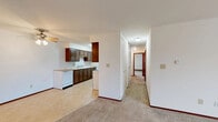 Located at 612 15th Place in Kenosha, Wisconsin, this three-bedroom, one-bathroom single-floor residence offers a functional and well-organized layout across a comfortable footprint. The open kitchen and dining area features a galley-style kitchen equipped with dark wood cabinetry, ample counter space, white appliances including a coil-top range, refrigerator, and dishwasher, and durable tile flooring. A ceiling fan overhead adds to the practicality of the combined space. The adjacent living room is generously sized, finished with neutral carpet, and features sliding glass doors with vertical blinds that lead out to a private balcony — bringing in natural light and outdoor views of the surrounding grounds. The exterior of the building showcases a classic mid-century brick facade with individual balconies. Each of the three bedrooms is carpeted and fitted with closet access, with the primary bedroom offering a notably spacious feel. The full bathroom includes a tiled tub/shower combination, tile flooring, and warm wood cabinetry. A long hallway lined with multiple closets provides exceptional storage throughout. Baseboard heating is present throughout the unit, ensuring efficient climate control during Wisconsin winters.