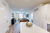 Located on Pine Place in La Plata, Maryland, this single-story, 2-bedroom, 2-bathroom residence offers a thoughtfully designed open-concept layout that maximizes its comfortable footprint. Warm hardwood-style flooring flows throughout the main living areas, creating a cohesive and inviting atmosphere.

The heart of the home is a bright, open kitchen, dining, and living area. The kitchen features crisp white shaker-style cabinetry, gleaming quartz countertops, a subway tile backsplash, stainless steel appliances including a French door refrigerator and range, and a central island with built-in shelving — ideal for casual dining or meal prep. The living and dining areas are bathed in natural light from multiple windows and are anchored by a ceiling fan overhead.

The primary bedroom is a serene retreat, comfortably sized, with access to a private en-suite bathroom featuring a glass-enclosed shower, white vanity cabinetry, and hardwood-style flooring. The second bedroom is equally well-proportioned, with its own access to a full bathroom complete with a tub and shower combination. Five closets distributed throughout the residence provide generous storage. A welcoming entrance foyer completes this clean, modern, and functional home.