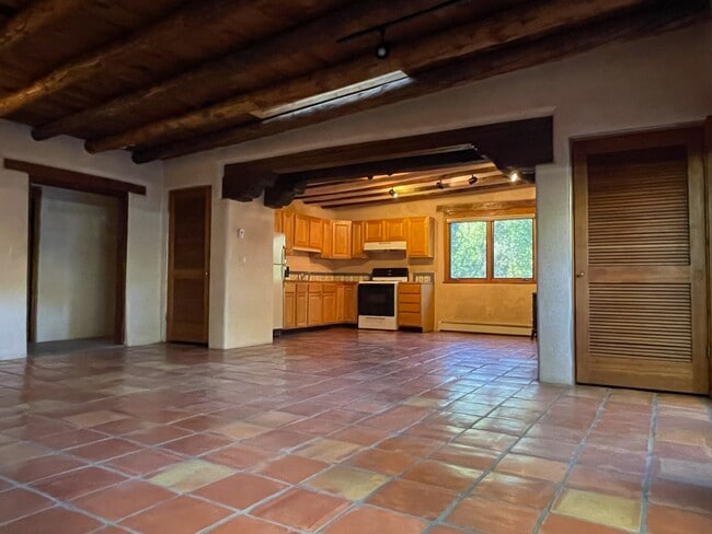 Living Room with vigas and corbels looking into kitchen - 1470B Bishops Lodge Rd