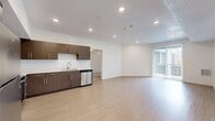 This modern single-story residence in Midvale, Utah, offers a well-designed layout with three bedrooms, two bathrooms, a dedicated closet, and a hallway connecting the living spaces. The open-concept kitchen and living area serves as the heart of the home, featuring light wood-style flooring, recessed lighting, and a sliding glass door that opens to a balcony, filling the space with natural light. The kitchen is outfitted with rich dark wood cabinetry, light countertops, a full suite of stainless steel appliances including a refrigerator, range, microwave, and dishwasher, and a deep undermount sink. The spacious primary bedroom includes a ceiling fan, plush carpeting, access to a walk-in closet, and direct entry to a private bathroom. The secondary bedrooms also feature soft carpeting and windows with exterior views. Both bathrooms are finished consistently with wood-toned vanities, white countertops, large mirrors, tub-shower combinations, and wood-style flooring. The overall aesthetic throughout is clean and contemporary, with a neutral white and warm wood palette that creates a bright, cohesive ambiance ideal for comfortable everyday living.