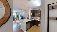 Located at 2101 Arlington Blvd in Charlottesville, VA, this thoughtfully designed two-bedroom, two-bathroom residence offers a functional and comfortable single-floor layout. The kitchen is a standout feature, equipped with dark espresso cabinetry, stainless steel appliances including a refrigerator, range, and built-in microwave, complemented by granite countertops and pendant lighting over a breakfast bar with sink — ideal for both meal prep and casual dining. The living room is bright and welcoming, with hardwood-style flooring, a ceiling fan, and access to a private balcony that overlooks lush greenery, filling the space with natural light. Both bedrooms are carpeted and feature ceiling fans, large windows with tree-lined views, and generous proportions. The primary bedroom is particularly spacious, offering ample room for full bedroom furnishings. The second bedroom also includes balcony access, making it versatile as a sleeping or workspace. Each bathroom features dark vanity cabinetry, white countertops, large mirrors, and hardwood-style flooring. The overall ambiance throughout the residence is clean, modern, and light-filled, with a neutral color palette that creates a cohesive and inviting atmosphere.