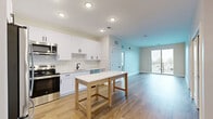 Located at 7220 Midlothian Turnpike in Richmond, VA, this thoughtfully designed 2-bedroom, 2-bathroom residence offers a clean, contemporary aesthetic across a well-organized single-floor layout. The open-concept kitchen and living area serves as the heart of the home, showcasing white shaker cabinetry, a classic subway tile backsplash, stainless steel appliances including a refrigerator, range, and over-the-range microwave, and light wood-style flooring that extends throughout the main living spaces. Sliding glass doors in the living area open to a private balcony, filling the space with natural light and offering outdoor views. The primary bedroom is generously sized, featuring plush carpeting and access to a well-appointed en-suite bathroom complete with a glass-enclosed walk-in shower and a white vanity with black hardware accents. The second bedroom also features carpeting, a ceiling fan, and a bright window with outdoor views. The second full bathroom includes a tub-shower combination, white tile surround, and matching black fixtures. Additional conveniences include three closets for ample storage and a dedicated laundry area. The consistent use of black hardware, neutral tones, and modern finishes throughout creates a cohesive and inviting living environment.