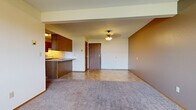 Located at 102 14th St NE in Buffalo, Minnesota, this single-floor unit offers a practical and functional layout designed for comfortable everyday living. The open-concept living and dining area serves as the heart of the space, featuring plush carpeting, a textured ceiling, and a combination of tile and carpet flooring that transitions seamlessly between zones. A ceiling light fixture illuminates the entryway, which features a solid wood door and tile flooring. The living area is complemented by a wall-mounted air conditioning unit and baseboard heating for year-round comfort, along with a window that lets in natural light.

The kitchen is efficiently laid out with warm wood cabinetry, granite-look countertops, and tile flooring. It is fully equipped with a white electric range, dishwasher, and refrigerator, along with ample upper and lower cabinet storage and under-cabinet lighting at the peninsula.

The bedroom is a calm, carpeted retreat featuring a wide window with outdoor views, baseboard heating, and a generously sized closet with a bi-fold door, a hanging rod, and a shelf for organized storage.

The bathroom includes a single-sink vanity with wood cabinetry, a full tub and shower combo, tile flooring, and chrome hardware throughout, offering a clean and utilitarian finish.