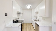 This 2-bedroom, 2-bathroom residence in Chino, CA offers a thoughtfully arranged single-floor layout that makes efficient use of its space. The galley-style kitchen is a standout feature, showcasing crisp white cabinetry, quartz-style countertops, light wood-look flooring, and stainless steel appliances including an electric range and dishwasher — all beneath a clean flush-mount ceiling light. The kitchen opens toward a dining area with a ceiling fan and a window that invites natural light. The living room is carpeted and spacious, with a sliding glass door that leads to a private balcony offering outdoor views, complemented by a skylight overhead and a textured ceiling throughout. Both bedrooms are carpeted and bathed in natural light from well-placed windows. The primary bedroom is generously sized and includes a wide sliding-door closet with ample storage. The two bathrooms each feature a tub-shower combination enclosed by sliding frosted glass doors. The primary bathroom is further enhanced by a large vanity mirror and marble-style countertops, adding a refined touch. White walls and neutral tones throughout the home create a clean, airy ambiance that is both functional and inviting.