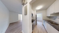 Located at 86 Cedar St S in Kitchener, Ontario, this well-appointed 2-bedroom, 1-bathroom unit offers a clean, modern aesthetic throughout. Light wood laminate flooring flows seamlessly across all living spaces, complementing the crisp white walls and creating a bright, airy atmosphere.

The open living room is a standout feature, bathed in natural light through large sliding glass doors that lead to a private balcony with pleasant views of mature trees and the surrounding neighbourhood. An additional side window further enhances the sense of openness.

The galley-style kitchen is efficiently designed with white cabinetry, dark countertops, white subway tile backsplash, and a full suite of stainless steel appliances including a stove, microwave, and refrigerator. A window at the end of the kitchen brings in additional natural light.

The spacious primary bedroom offers generous proportions and features a built-in sliding closet, allowing for ample storage. The second bedroom is equally bright, with wide windows that invite natural light. Both rooms are finished with the same warm wood flooring and neutral white walls.

The bathroom is finished with classic white subway tile surrounding a full soaker tub and shower combination, paired with chrome fixtures for a clean, timeless look. A hallway connects all rooms, providing a practical and well-organized layout throughout.