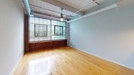 Located at 237 Jacksonville Rd in Hatboro, PA, this two-floor loft-style space showcases an impressive blend of industrial character and modern finishes. Throughout the unit, warm hardwood flooring runs seamlessly, complementing the exposed brick accent walls that lend a rich, textural quality to the interior. Soaring ceilings with white-painted wood planking and exposed ductwork reinforce the industrial aesthetic, while ceiling fans provide both function and visual interest.

Large, multi-pane industrial windows flood the living areas with abundant natural light and offer views of the surrounding exterior. The open-concept layout connects the living and dining areas to a well-appointed kitchen, which features a peninsula with a dark granite countertop, warm wood cabinetry, pendant lighting, and stainless steel appliances including a gas range, microwave, and refrigerator.

The bathrooms are cleanly finished, with classic white subway tile wainscoting, dark granite vanity tops, and a shower-tub combination. Additional storage is provided by a closet outfitted with wire shelving and hanging rods. The two-floor layout offers functional separation of living spaces, making this a distinctive and characterful property in the Hatboro community.