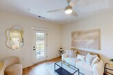 This thoughtfully designed single-floor residence in Valdosta, Georgia, offers a cohesive, modern aesthetic throughout its efficiently organized layout. The open-concept kitchen and living area serves as the heart of the home, where a sleek white kitchen with subway tile backsplash, stainless steel appliances — including a gas range, built-in microwave, and French door refrigerator — and a large peninsula with bar seating flows seamlessly into the living space. Light wood flooring runs throughout, enhancing the bright, airy atmosphere created by neutral warm-white walls and recessed lighting. The living room is generously sized for the layout, featuring a ceiling fan and a glass door that opens to a private balcony with open outdoor views. The bedroom offers a comfortable retreat with a ceiling fan, natural light from a window with sheer curtains, and a double-door closet. The full bathroom is clean and functional, featuring white subway tile surrounding a soaking tub and shower combination with matte black hardware accents. A dedicated laundry room with shelving and utility hookups adds everyday convenience. The hallway connects all areas efficiently, completing this well-planned and modern living space.