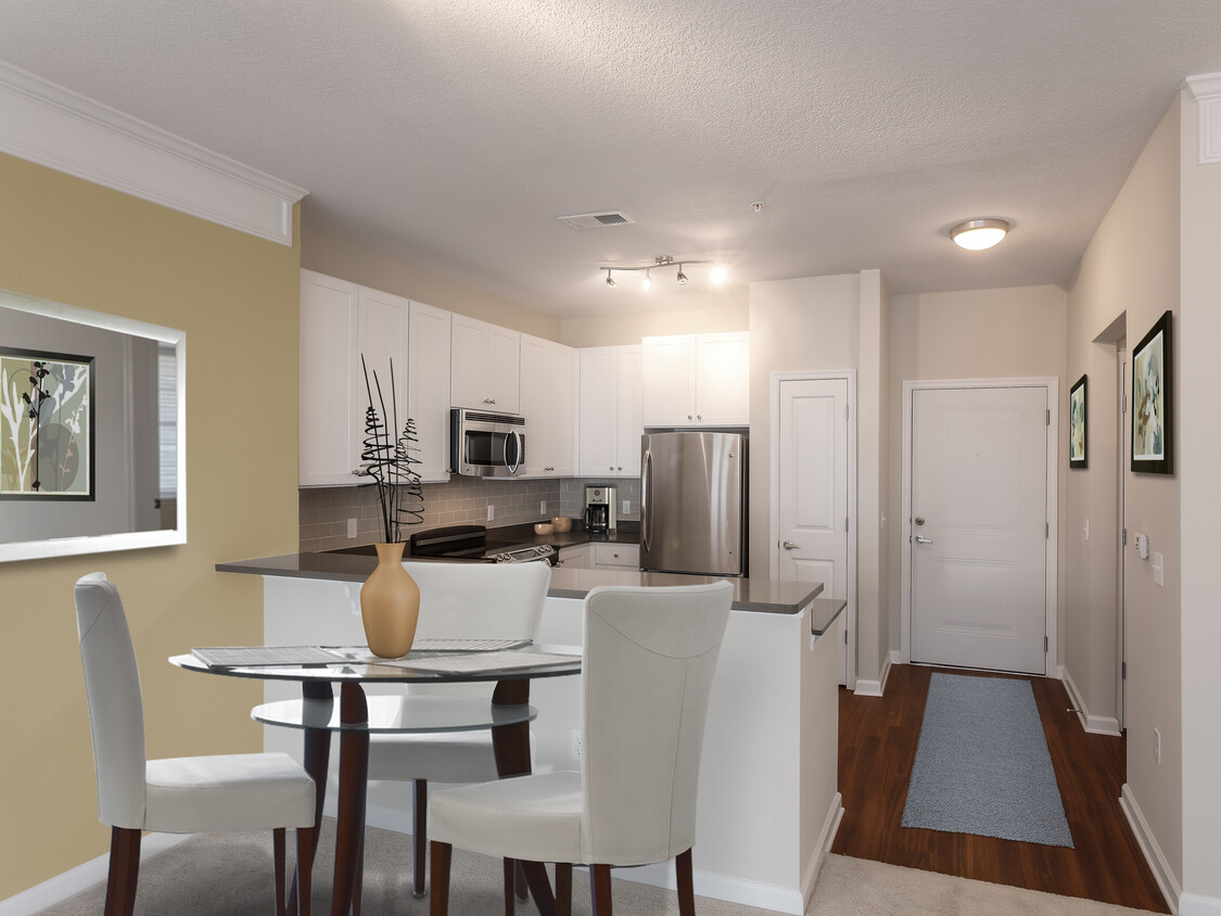 Dining area and kitchen with quartz stone countertop, white cabinetry, tile backsplash, stainless steel appliances and hard surface flooring - Avalon Arlington North