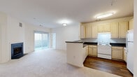 Located at 108 Olde Towne Ave in Gaithersburg, Maryland, this two-bedroom, two-bathroom residence offers a well-designed single-floor layout with a bright, neutral palette throughout. The open-concept living and dining area is anchored by a classic fireplace and features plush wall-to-wall carpeting, with a sliding glass door that fills the space with natural light and provides access to an outdoor area. The kitchen flows seamlessly from the living space, separated by a peninsula with dark countertops. It features warm wood-toned cabinetry, white appliances, and durable hardwood-style flooring, offering both functionality and style. The generously sized primary bedroom includes a spacious walk-in closet outfitted with wire shelving on multiple levels, providing ample storage. The second bedroom is well-proportioned, offering a large window with neighborhood views and a standard closet with built-in shelving. Both bathrooms are finished with tile flooring, full tub-shower combinations, light wood vanities, and large mirrors. Additional storage is accessible via louvered closet doors near the kitchen. The overall ambiance is clean, comfortable, and move-in ready, making it a practical and inviting home in the heart of Olde Towne Gaithersburg.