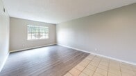 Located at 6601 Old Shell Rd in Mobile, Alabama, this 2-bedroom, 1-bathroom residence offers a practical and well-organized single-floor layout. The living area features light gray luxury vinyl plank flooring paired with neutral-toned walls and a textured ceiling, creating a clean and modern aesthetic. A large window allows natural light to flow in, offering views of the surrounding greenery.

The galley-style kitchen is efficiently designed with white cabinetry on both sides, light countertops, tile flooring, and a full suite of white appliances including an electric range, refrigerator, and dishwasher. An overhead range hood adds functionality to the cooking space.

The primary bedroom is generously sized, featuring the same LVP flooring and a window with outdoor views, providing a bright and comfortable retreat. The second bedroom is similarly finished with neutral walls and wood-look flooring, along with its own window for natural light. A dedicated hallway connects the rooms and leads to a closet for additional storage.

The shared bathroom is appointed with a full-size soaking tub and shower combo, accented by large-format marble-style wall tiles in white with subtle veining, lending a clean and elevated feel. Throughout the unit, the consistent use of neutral tones and modern finishes creates a cohesive and move-in ready atmosphere.