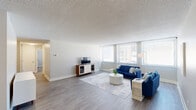 Located at 1801 E 12th St in Cleveland, Ohio, this 2-bedroom, 1-bathroom residence offers a thoughtfully designed single-floor layout with a clean, modern aesthetic throughout. Light gray hardwood-style flooring and textured ceilings carry consistently through the space, establishing a cohesive and contemporary feel.

The expansive living room serves as the heart of the home, featuring a bank of large windows fitted with horizontal blinds that flood the room with natural light. The adjacent dining area provides a comfortable space for meals, positioned just steps from a well-equipped galley kitchen. The kitchen is outfitted with white shaker cabinetry, quartz countertops, stainless steel appliances, and ample storage — a practical and stylish setup for everyday cooking.

The generously sized primary bedroom benefits from large windows that bring in natural light and include two closet areas, offering excellent storage. The second bedroom provides additional flexible living space, also featuring a closet and hardwood-style flooring. The bathroom is finished with white subway tile, a glass-enclosed shower, and a marble-topped vanity, combining clean lines with refined detailing.

With six closets distributed throughout, storage is a standout practical feature of this residence. The neutral color palette, modern finishes, and abundant natural light create a bright and welcoming atmosphere throughout.
