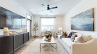 Located at 101 S Dean Ave in Raymore, MO, this thoughtfully designed 2-bedroom, 2-bathroom residence offers a seamless blend of modern aesthetics and functional living on a single floor. Light-toned hardwood flooring flows throughout, tying the spaces together with a clean, cohesive look.

The bright living room features a ceiling fan, recessed lighting, and multiple windows that flood the space with natural light, creating an open and airy atmosphere. The modern kitchen is a standout, showcasing light wood cabinetry, white subway tile backsplash, stainless steel appliances, and a central island with bar seating — ideal for both cooking and casual dining.

The primary bedroom offers a comfortable, well-proportioned retreat with warm natural light from a large window. The second bedroom is equally inviting, also benefiting from generous window placement. Both bathrooms are finished with light wood vanities, quartz-style countertops, undermount sinks, and clean-lined hardware. One bathroom features a walk-in glass-enclosed shower, while both maintain a consistent modern design sensibility.

Two hallways connect the rooms efficiently, and a dedicated closet adds practical storage. The overall ambiance is contemporary and calm, with a neutral color palette and quality finishes throughout.