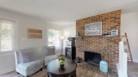 Located at 219 Perth Dr in Dublin, Ohio, this two-story home blends classic charm with modern updates throughout its thoughtfully designed layout. The main living area serves as the heart of the home, anchored by a striking full-height brick fireplace with a wood mantel that adds warmth and character. Wood-look flooring flows through the main level, connecting the living space to a dedicated dining area and an updated kitchen. The kitchen features white shaker-style cabinetry, granite countertops, stainless steel appliances, and a double-basin sink — offering both style and functionality in a well-organized galley layout. Two bathrooms are finished with white vanities, wood-look flooring, and large mirrors, providing a clean and bright aesthetic. The upper level includes carpeted bedrooms with neutral tones and natural light from windows overlooking the surrounding neighborhood. At least one bedroom features a built-in closet with a sliding door. An open staircase with white railings connects the two floors, contributing to the home's open and airy feel. Throughout, the consistent use of neutral paint tones, updated fixtures, and natural light creates a welcoming and move-in-ready atmosphere.