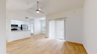 This single-story, 2-bedroom, 2-bathroom residence offers a thoughtfully designed layout that maximizes its compact footprint. The open-concept living area immediately draws attention with its vaulted ceilings and ceiling fan, creating a sense of spaciousness. Light wood-style flooring extends throughout the main living spaces, while large vertical-blind-covered sliding glass doors invite natural light and provide outdoor access.

The kitchen is a standout feature, equipped with white shaker-style cabinetry, granite countertops, a peninsula with an undermount sink, and a full suite of stainless steel appliances including a refrigerator, electric range, and built-in microwave. A dedicated dining nook adjacent to the kitchen features a window with natural light.

The primary bedroom offers a generous footprint with vaulted ceilings, a ceiling fan, a sliding glass door, and plush carpeting. The secondary bedroom is similarly carpeted with a ceiling fan and natural light from a window. Both bathrooms are well-appointed with granite-topped white vanities, framed mirrors, and tub/shower combinations with tile surrounds. A hallway and closet complete the functional layout.