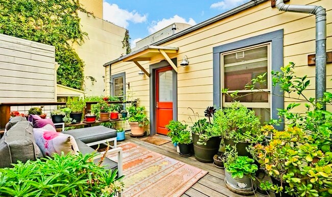 Private sun deck with a lemon tree, jade plants, succulents, rosemary, sage, lavender, and flowers. - 328 Harriet St Townhome