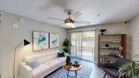 This single-floor residence offers a functional and thoughtfully designed layout across two bedrooms and two bathrooms. The living room serves as the central gathering space, featuring wood-style flooring, a ceiling fan with integrated lighting, and a sliding glass door that opens to a private patio, allowing natural light and outdoor views to enhance the room's ambiance. A built-in shelving unit adds both storage and character to the space.

The kitchen is outfitted with white cabinetry, stainless steel appliances including a gas range and refrigerator, a tile backsplash, and a light-toned countertop with an undermount sink. It connects seamlessly to a dedicated dining area, which features wood-style flooring, a pendant light fixture, and a softly colored accent wall.

The primary bedroom includes carpet flooring, a ceiling fan, a window with outdoor views, and a walk-in closet with wire shelving for organized storage. The second bedroom also features carpet and a sliding double-door closet. Both bathrooms are well-equipped; one includes a single-sink vanity with white cabinetry and a tub-shower combination, while the second offers a more compact layout with textured walls and decorative accents throughout.