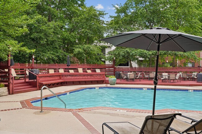 Piscina y solárium con asientos al aire libre y tumbonas. - Rolling Brook Village