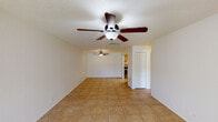 Summit West One Bedroom A1 - 2B is a thoughtfully laid-out single-floor residence that offers a comfortable and functional living experience. The open living and dining area is finished with warm tile flooring and features dual ceiling fans that promote airflow throughout the space. A large front window and entry door allow natural light to fill the room, creating a bright and welcoming atmosphere.

The galley-style kitchen is outfitted with wood-toned cabinetry, tile backsplash, light countertops, a double basin sink, and stainless steel appliances including a refrigerator with ice maker and an electric range. Conveniently tucked just off the kitchen is an in-unit laundry area with a washer and dryer included.

The bedroom is a generously sized retreat featuring plush wall-to-wall carpeting, a ceiling fan with light fixture, and a large window overlooking a green outdoor view, providing a serene and restful environment. A closet offers practical storage.

The bathroom is clean and functional, featuring a tiled tub-shower combination with chrome fixtures, a single vanity with sink, and a lighted mirror. A shelved linen closet is conveniently accessible from within the bathroom. The textured ceilings throughout add a classic finishing touch to this well-maintained residence.