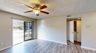 Located at 1108 Saint Andrews Dr in Wilmington, NC, this well-appointed one-bedroom, one-bathroom residence offers a functional and comfortable layout across a single floor. The living room serves as the heart of the home, featuring light-toned luxury vinyl plank flooring, a ceiling fan with light fixture, a textured ceiling, and a sliding glass door that fills the space with natural light and provides direct access to the outdoors. The galley-style kitchen is efficiently designed with crisp white shaker cabinetry, stone-patterned countertops, stainless steel appliances including a refrigerator and electric range, a built-in dishwasher, and a single-basin sink — all complemented by matching LVP flooring and a round flush-mount ceiling light. The bedroom offers plush carpeting, a ceiling fan, a window with exterior views, and a dedicated closet with a hanging rod for ample storage. The bathroom includes a clean, white tub and shower surround with a built-in towel bar. A hallway connects the rooms, maintaining a smooth flow throughout. Neutral tones and consistent finishes give this residence a cohesive, move-in-ready feel.