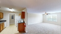 Located at 2815 Kinloch Ct in Florence, South Carolina, this single-story 2-bedroom, 2-bathroom home offers a functional and comfortable layout across a well-proportioned floor plan. The open-concept design connects the kitchen directly to the living area, creating a seamless flow ideal for everyday living. The kitchen is well-equipped with warm wood cabinetry, dark laminate countertops, a double basin sink, white appliances including a coil-top range, microwave, and refrigerator, and is finished with light tile flooring. A dedicated utility room is conveniently accessible from the kitchen. The spacious living room features plush carpeting, crown molding, a ceiling fan with light fixture, and a window that invites natural light into the space. The generously sized primary bedroom also features carpet flooring, a ceiling fan, crown molding, a large window, and a walk-in closet outfitted with wire shelving. The second bedroom includes carpet flooring, a ceiling fan, and a sliding-door closet. Both bathrooms are equipped with a single vanity with wood cabinetry, a tub-shower combination, and tile flooring. A textured ceiling is consistent throughout the home, adding a classic residential character to the overall space.