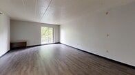 Located at 1170 Bower Hill Rd in Pittsburgh, PA, this one-bedroom, one-bathroom unit offers a practical and well-organized single-floor layout. The living area is bright and open, featuring durable hardwood-style plank flooring, neutral white walls, and a textured ceiling that adds subtle character. A sliding glass door opens to a private balcony overlooking lush greenery, allowing natural light to fill the space and providing pleasant outdoor views. A large built-in closet with louvered doors offers ample storage directly within the living area. The kitchen connects seamlessly to the main living space and includes wood-toned cabinetry, providing functional storage and workspace. The bedroom is comfortably sized and features soft wall-to-wall carpeting, a window with leafy outdoor views, and a dedicated closet, creating a quiet and restful retreat. The bathroom is equipped with a full tub-shower combination featuring stainless steel grab bars for added safety and accessibility, along with clean white fixtures. Throughout the unit, dark baseboards provide a clean contrast to the light walls, tying the design together with a cohesive, understated aesthetic.
