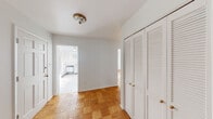 Located at 124 E Melrose Ave in Baltimore, MD, this single-floor residence offers a straightforward and functional layout throughout. A consistent design element unifies the space: warm, checkerboard-pattern parquet wood flooring extends through the living areas and bedrooms, adding a classic character to the clean, white-walled interiors.

The kitchen is outfitted with white cabinetry, a gas range, built-in microwave, full-size refrigerator, and wall oven, all set against marble-look tile flooring. Natural light from a window brightens the space. The bedroom areas are generously sized, each featuring the distinctive parquet flooring, large windows that invite natural light, and louvered bi-fold closet doors offering substantial storage. One bedroom includes a notably wide, multi-panel closet wall for expanded storage capacity.

The unit includes two full bathrooms. The first features a vintage-style design with bold yellow subway tile wainscoting, a glass-enclosed shower stall, a large window with outdoor views, and mosaic tile flooring. The second bathroom presents a more neutral palette with sage-green subway tile wainscoting, mosaic tile flooring, a long vanity with mirror cabinet, and a separate shower area. Together, these spaces deliver a well-organized, light-filled residence in a Baltimore neighborhood setting.