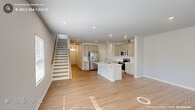 Located in Durham, NC, this well-appointed two-story home offers 3 bedrooms and 3 bathrooms across two thoughtfully designed floors. The main level features an open-concept living and kitchen area bathed in natural light, with light hardwood-style flooring throughout. The kitchen is a standout, boasting a large center island with a built-in sink and white quartz countertops, gray shaker-style cabinetry, stainless steel appliances including a French door refrigerator and range, and recessed lighting. A staircase with a wood railing and modern black balusters connects the two floors seamlessly. The upper level hosts all three bedrooms, including a generously sized primary suite with plush carpeting, a tray ceiling, dual windows for ample natural light, and an en-suite bathroom featuring a glass-enclosed tile shower, a wide vanity with white countertops, and tile flooring. Additional bedrooms offer carpeted or hardwood-style flooring with natural light. A dedicated laundry room with side-by-side washer and dryer adds everyday convenience. The home also includes an attached garage with an electrical panel, completing this functional and modern residence.