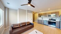 Located at 353 Vine St in West Lafayette, Indiana, this efficient 2-bedroom, 2-bathroom unit offers a well-designed single-floor layout. The open-concept living and kitchen area serves as the heart of the home, featuring light wood-style flooring, recessed lighting, and a ceiling fan. The kitchen is outfitted with wood-toned cabinetry, white countertops, a stainless steel refrigerator, range, microwave, and dishwasher, offering a clean and modern aesthetic. The living area provides ample natural light through dual windows with views of the surrounding neighborhood, complemented by a wall-mounted TV setup and ceiling fan. Both bedrooms feature neutral carpet flooring, ceiling fans, and dedicated closets, providing a cozy and functional retreat. The two bathrooms are finished with light flooring, warm-toned walls, matte black fixtures, and full tub-shower combinations. Additional highlights include three closets for generous storage, an in-unit laundry area, and a practical hallway connecting all rooms. The overall design is modern and clean, with a neutral color palette that creates a cohesive and move-in-ready atmosphere throughout.