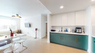 Located at 2566 Telegraph Ave in the heart of Berkeley, CA, this well-appointed single-floor unit offers a thoughtfully designed layout with multiple bedrooms, a full kitchen, and a bathroom finished with distinctive details throughout.

The kitchen is a standout feature, showcasing two-tone cabinetry with teal lower cabinets accented by gold hardware and crisp white upper cabinets. Light wood-look flooring runs throughout the space, lending warmth and continuity. The kitchen is fully equipped with stainless steel appliances, including a full-size range with microwave above and a full-size refrigerator, along with generous counter space and a sink along the extended prep area that opens toward the living zone.

The open-concept living and kitchen area flows naturally, with recessed lighting illuminating the space. A wall-mounted television and open sightlines contribute to a functional, comfortable common area.

The bedrooms are bright and airy, each featuring ceiling fans, window blinds for privacy and light control, and light wood flooring. The rooms comfortably accommodate multiple beds, making them well-suited for shared living.

The bathroom features classic penny tile flooring in a black-and-white pattern, teal vanity cabinetry with a white countertop, a backlit mirror, and brass fixtures — combining clean, modern design with timeless detail.