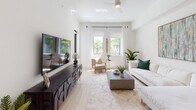 Located at 8021 Peters Rd in Plantation, FL, this single-floor residence combines contemporary design with a warm, welcoming ambiance. The kitchen is a standout feature, showcasing floor-to-ceiling white gloss cabinetry, crisp white quartz countertops, and a striking geometric-patterned tile backsplash. Stainless steel appliances, including a French door refrigerator, gas range, built-in microwave, and dishwasher, complete the sleek, functional layout. Light wood-tone flooring runs throughout, adding warmth to the bright, neutral palette. The open living area is filled with natural light from large windows and a glass door that opens to an outdoor balcony, framing views of lush tropical greenery. Polished tile flooring, soaring ceilings, and a tasteful mix of contemporary furnishings give the living space an airy, refined feel. The bedrooms are thoughtfully designed, each benefiting from generous natural light. One bedroom features a bold teal accent wall adorned with a gallery of framed artwork, while another offers a serene, neutral aesthetic with views of the surrounding landscape. Throughout, the design balances modern minimalism with vibrant accents, creating a cohesive and stylish living environment in the heart of Plantation, Florida.